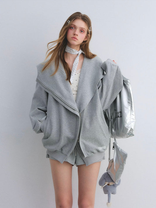 Woman wearing a gray outfit with a silver backpack on a white background