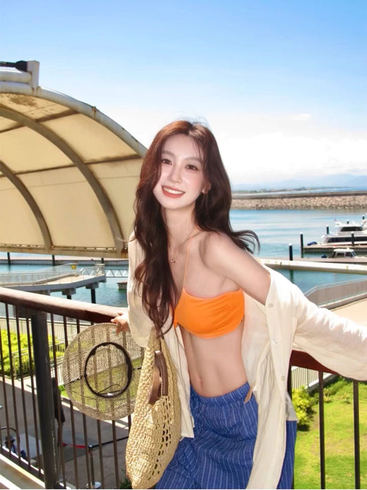INNA Amalfi Sunset orange asymmetric bikini top with blue striped cover-up at marina