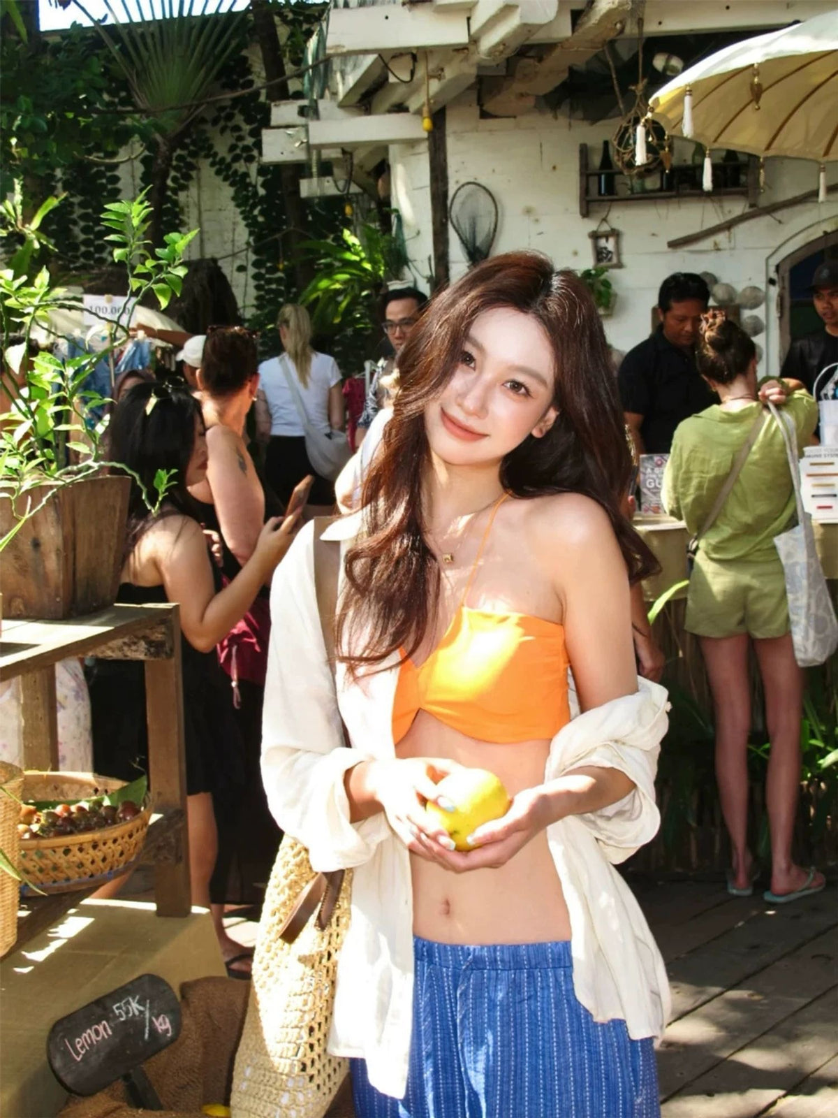 INNA Amalfi Sunset orange bikini top styled with a white cover-up in market setting